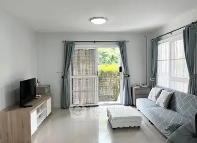 Bright and airy living room with modern decor and garden view, perfect for relaxation and entertainment.