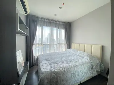 Cozy bedroom with city view, featuring modern decor and ample natural light.