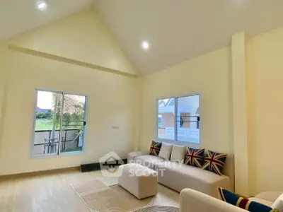 Spacious living room with modern decor and large windows offering natural light.