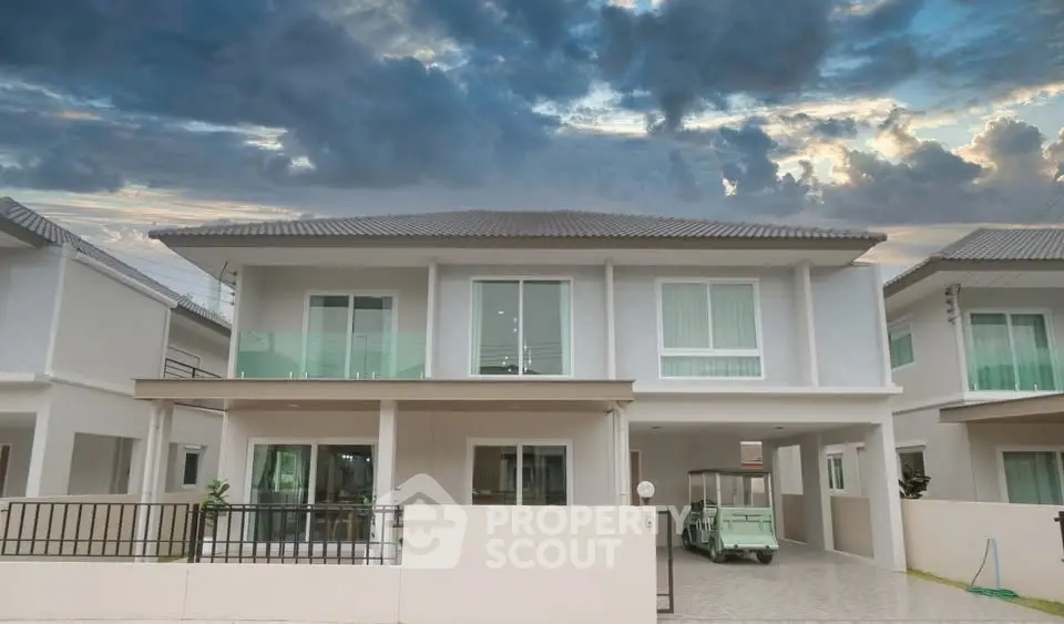 Modern two-story house with a spacious driveway and dramatic sky backdrop.