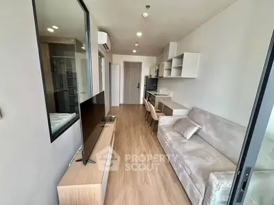 Modern living room with sleek furniture and open kitchen layout in a stylish apartment.