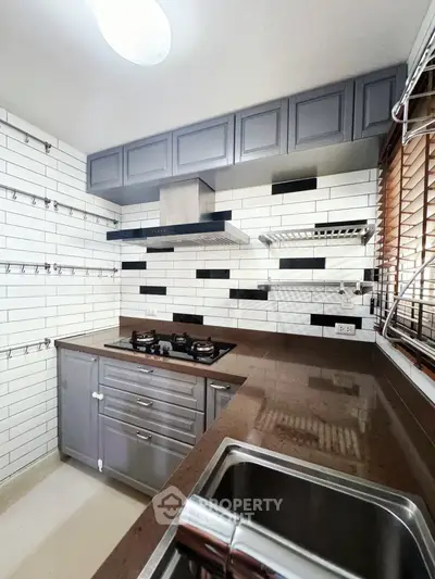 Modern kitchen with sleek cabinetry and gas stove in stylish apartment