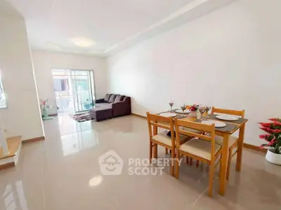 Spacious living room with dining area and balcony access, perfect for entertaining.