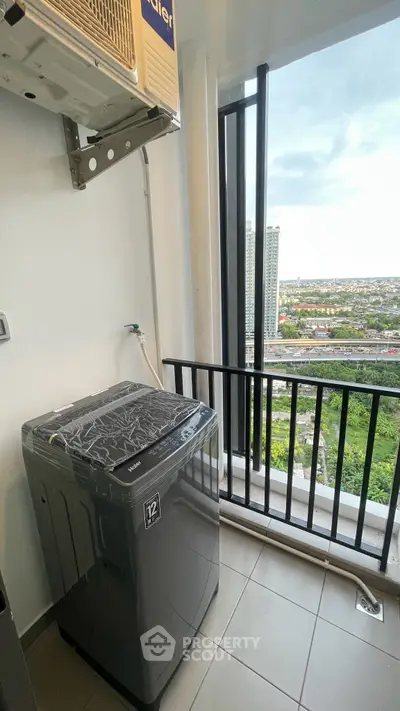 High-rise apartment balcony with washing machine and stunning city view.