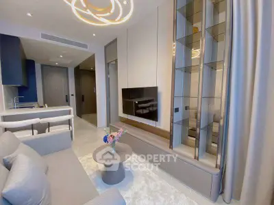 Modern living room with sleek design and open kitchen layout, featuring stylish furniture and elegant lighting.