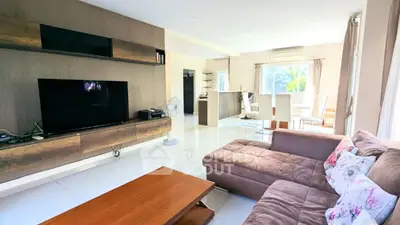 Spacious living room with modern decor and open layout, featuring a cozy sectional sofa and large TV unit.