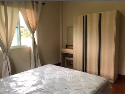 Cozy bedroom with natural light, featuring a comfortable bed and modern wardrobe.