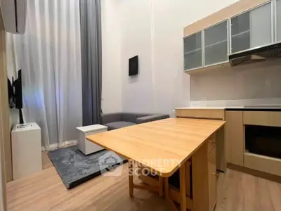 Modern studio apartment with open kitchen and cozy living area, featuring sleek cabinetry and stylish decor.