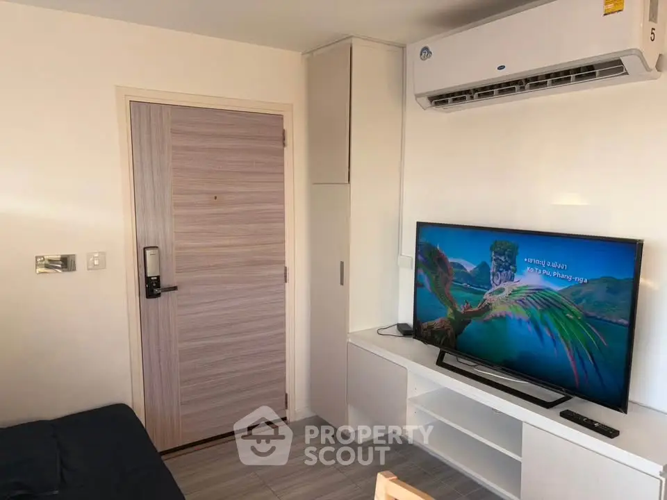 Modern living room with sleek TV setup and air conditioning in a cozy apartment.