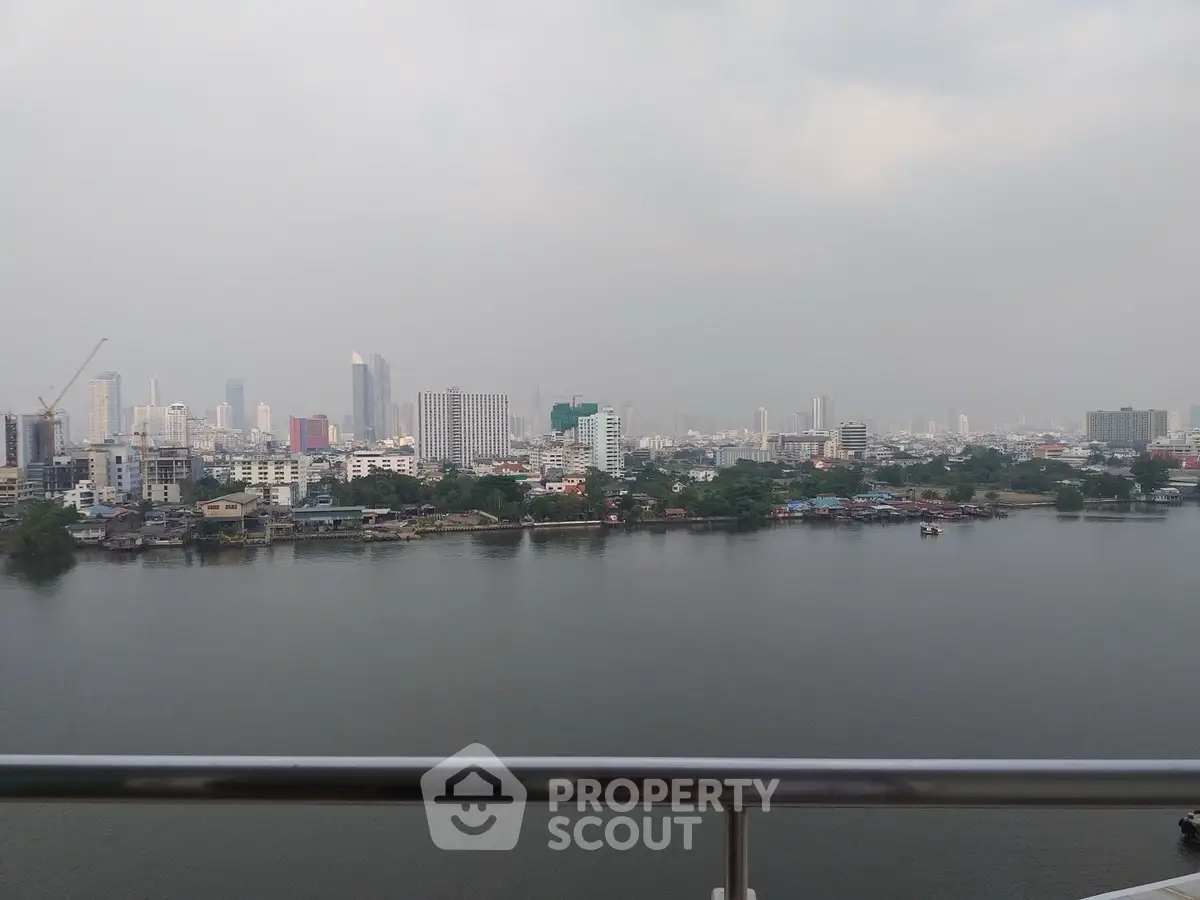 Stunning cityscape view from a high-rise balcony overlooking a serene river.