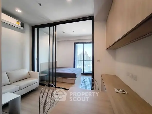 Modern studio apartment with open layout, featuring a cozy living area and a bedroom with city view.