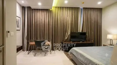 Modern bedroom with sleek furniture and ambient lighting, featuring a cozy workspace and stylish decor.