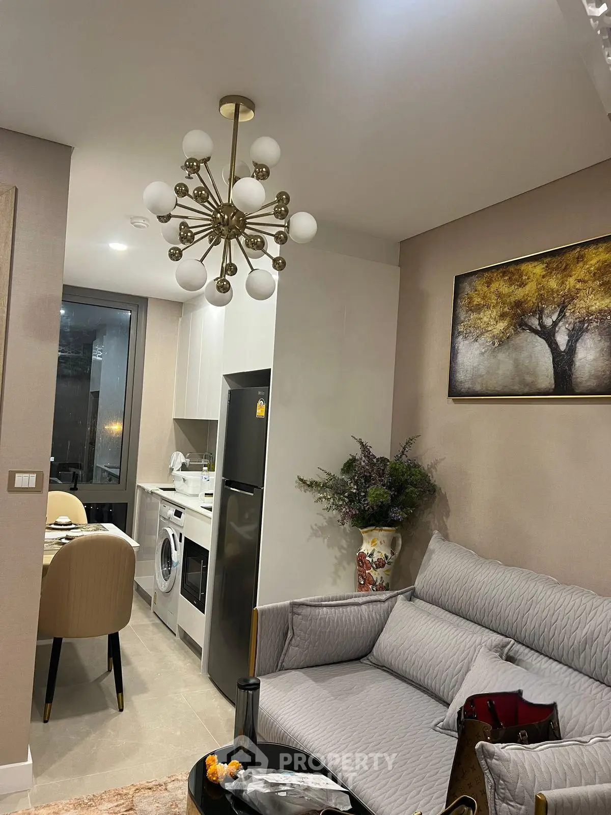 Modern living room with stylish chandelier and cozy kitchen area