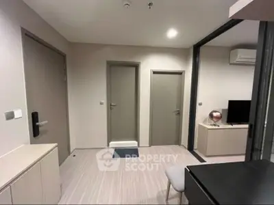 Modern apartment interior with sleek design and neutral tones, featuring a compact living area and stylish decor.