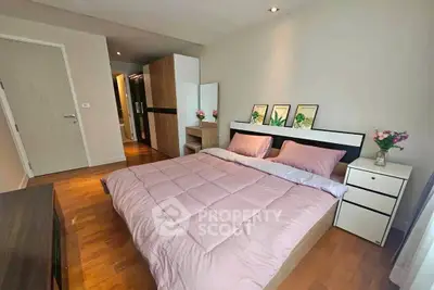 Spacious bedroom with modern decor and wooden flooring