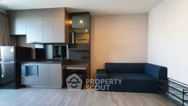 Modern living room with sleek furniture and compact kitchen area