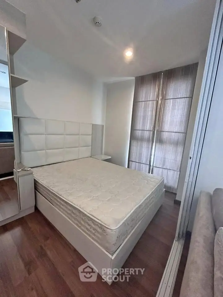Modern bedroom with stylish decor and ample natural light, featuring a comfortable bed and sleek wooden flooring.