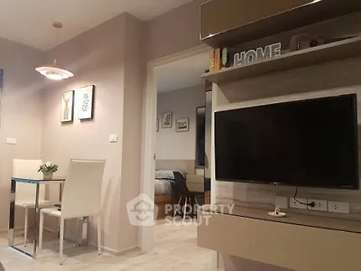 Modern living room with wall-mounted TV and dining area in stylish apartment