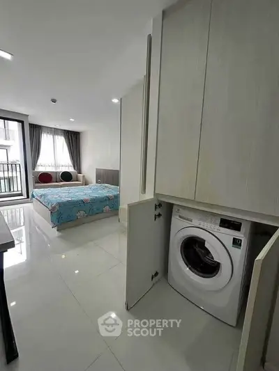 Modern bedroom with built-in washing machine and balcony view