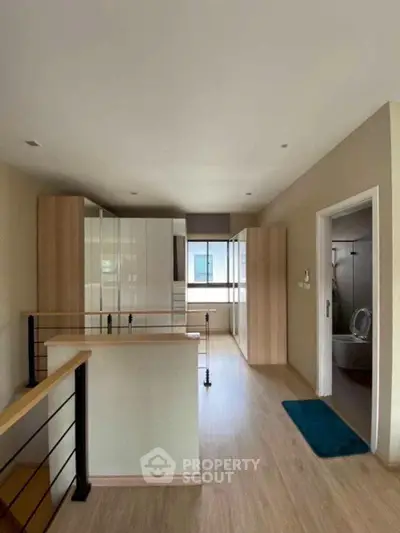 Modern open layout interior with wooden flooring and sleek kitchen design.