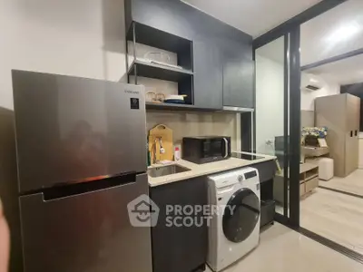 Modern kitchen with sleek appliances and open layout in stylish apartment.