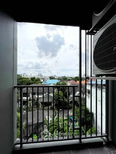 Urban balcony view with cityscape and lush greenery
