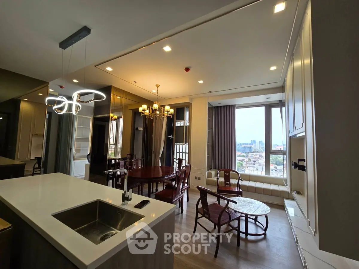 Modern open-plan living room with city view, featuring elegant dining area and stylish lighting fixtures.