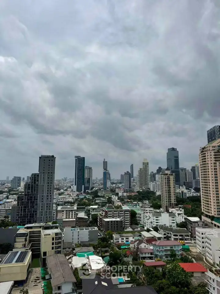 Stunning cityscape view from a high-rise building showcasing urban skyline and lush greenery.