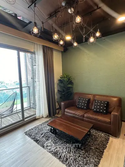 Stylish living room with leather sofa and modern lighting, adjacent to a balcony with city view.