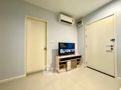 Modern living room with sleek TV setup and air conditioning in a stylish apartment.