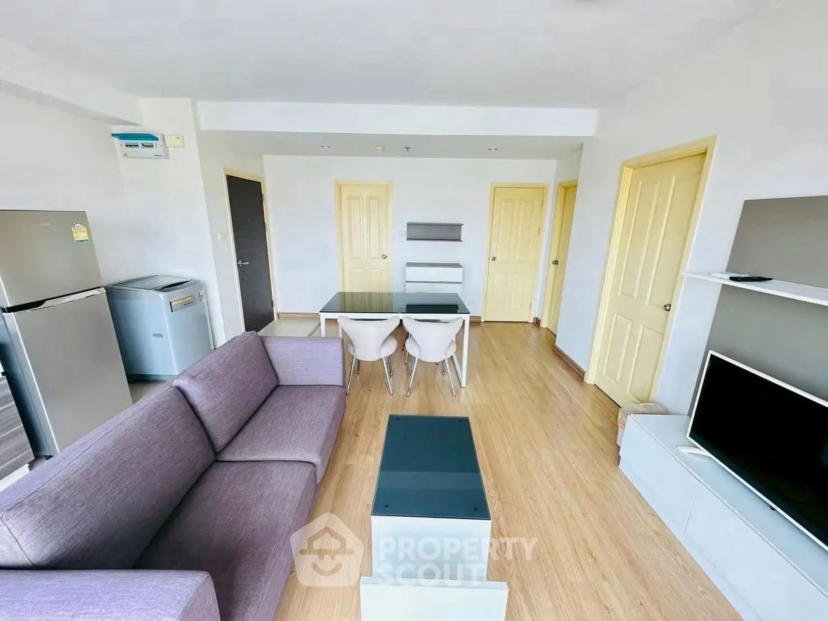 Modern living room with sleek furniture and open layout, featuring a dining area and stylish decor.