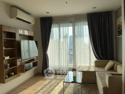 Modern living room with large windows and city view, featuring a cozy sofa and wall-mounted TV.