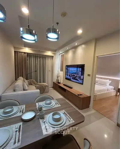 Modern living room with dining area and view into cozy bedroom