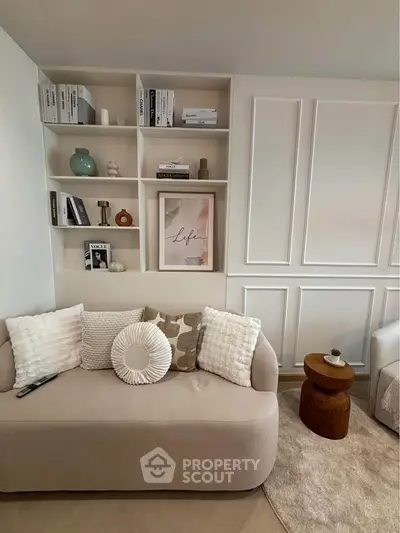 Stylish living room with modern decor and cozy seating, featuring elegant shelving and soft lighting.