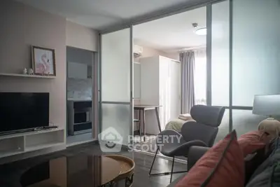 Modern living room with sliding glass doors leading to a cozy bedroom, featuring stylish furniture and natural light.