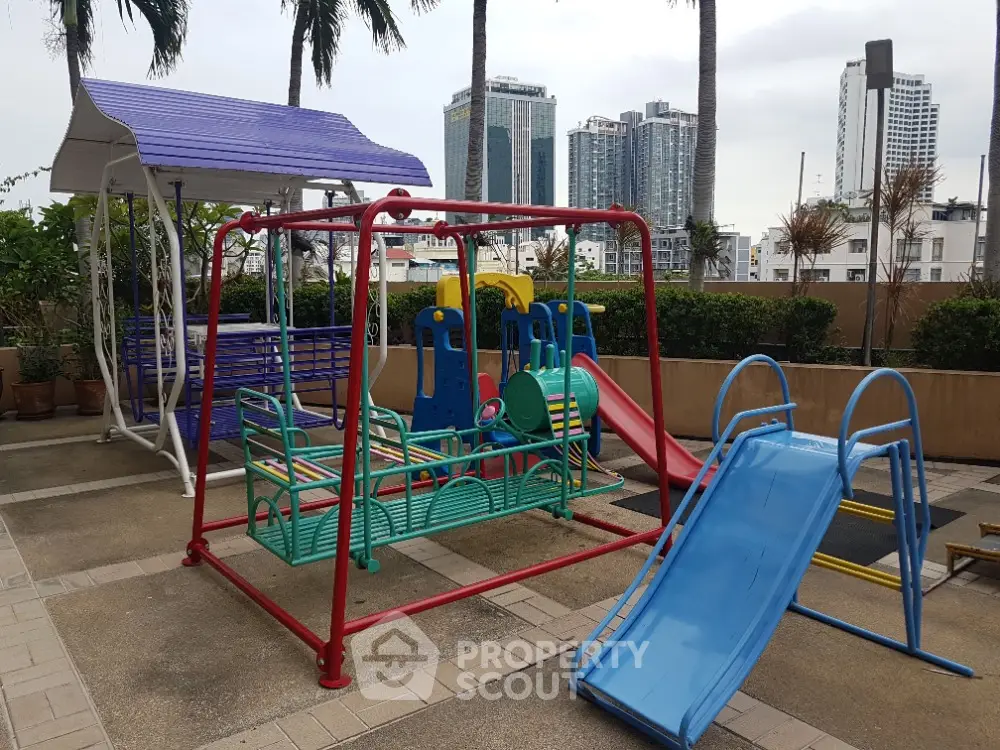 Modern urban playground with colorful slides and swings in a residential complex.