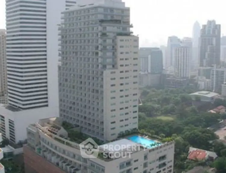 Luxurious high-rise building with rooftop pool and stunning city views.