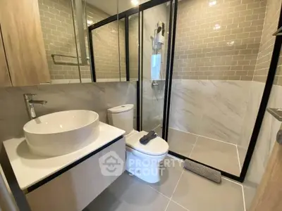 Modern bathroom with sleek design, featuring a glass shower enclosure and stylish vanity.