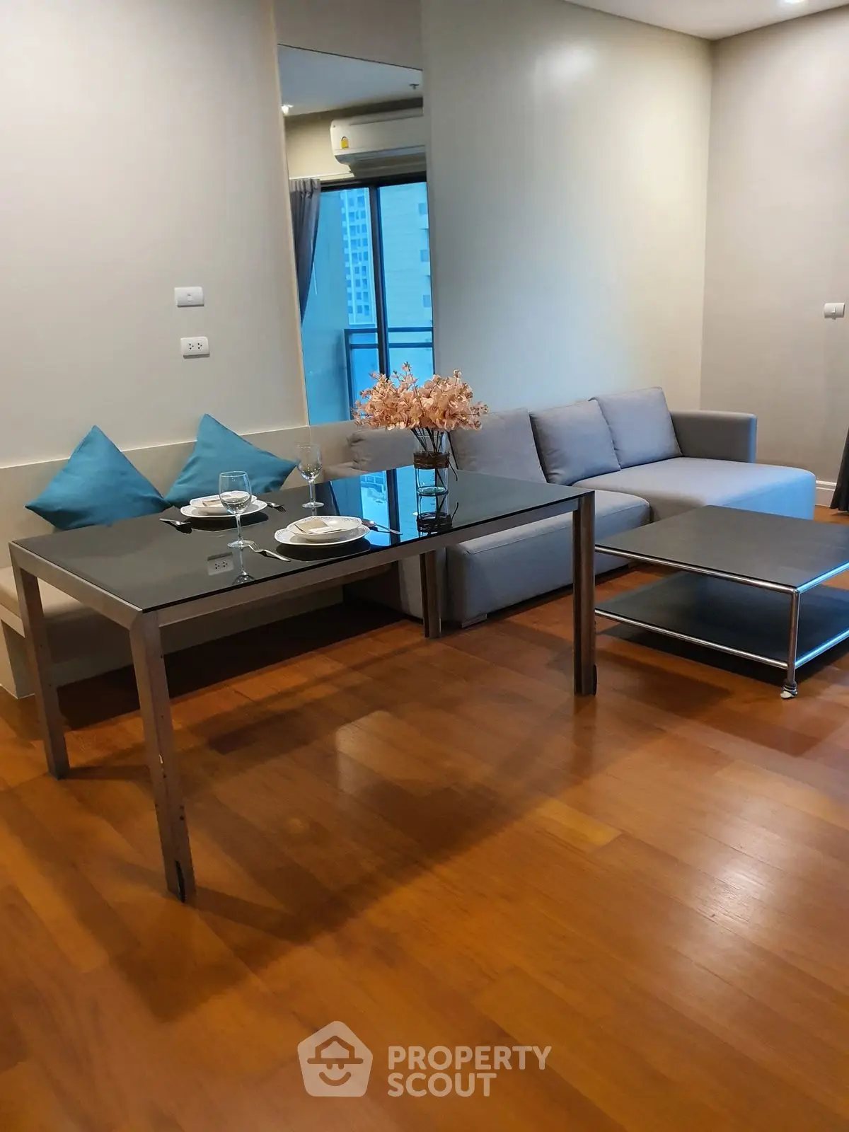Modern living room with sleek furniture and wooden flooring in a cozy apartment setting.