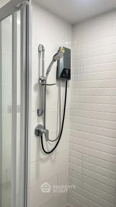 Modern bathroom with sleek shower and white tiled walls, perfect for a contemporary home.