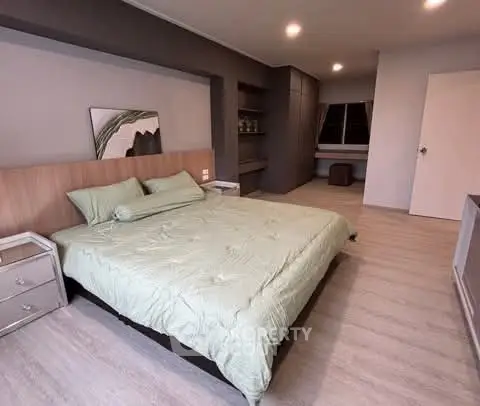 Spacious modern bedroom with stylish decor and ample natural light.