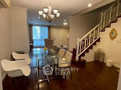 Elegant living room with glass dining table and stylish staircase in modern home