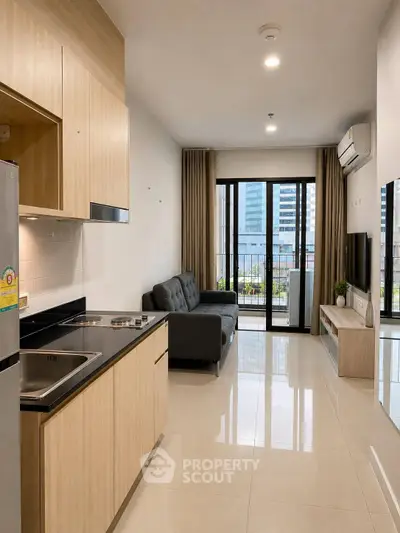 Modern open-layout living room with kitchen, featuring sleek design and city view balcony.