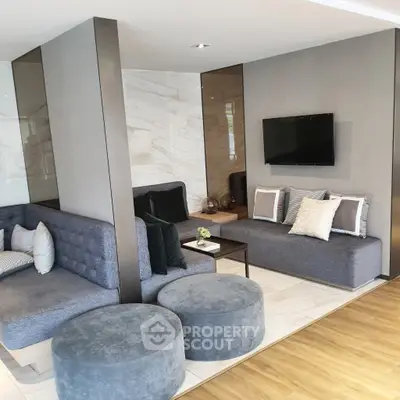 Modern living room with stylish gray seating and wall-mounted TV