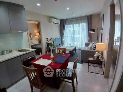 Modern open-plan living room and kitchen with cozy dining area and stylish decor.