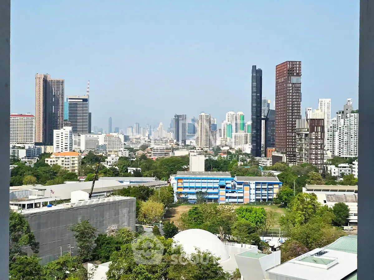Stunning cityscape view from a high-rise building, showcasing modern skyscrapers and lush greenery.