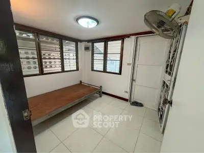 Spacious, well-lit bedroom with large windows, tiled flooring, and a built-in elevated bed platform, ideal for modern living.