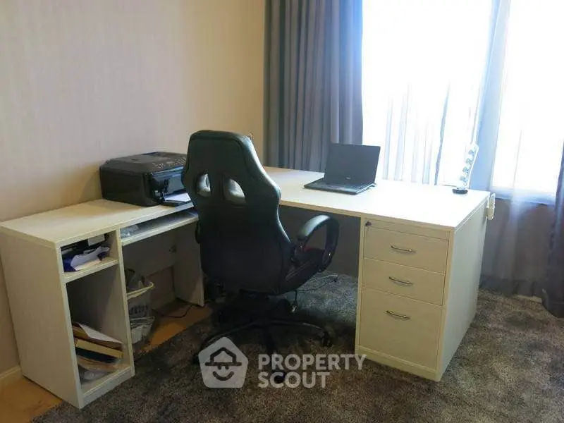 Modern home office with desk, chair, and printer in a bright room with large window.