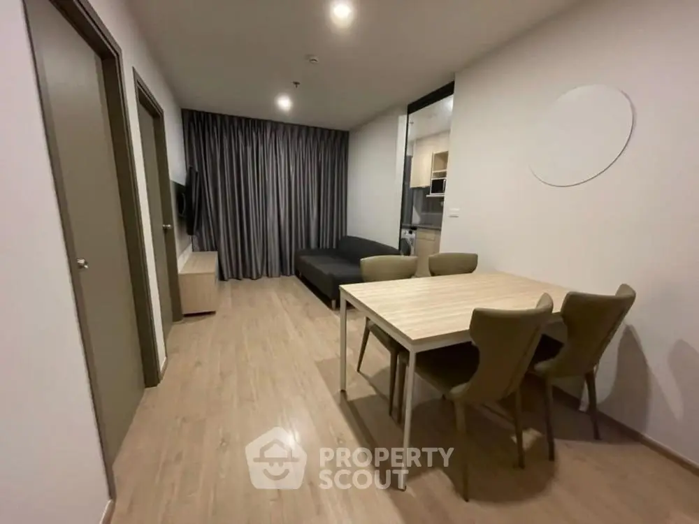 Modern living room with dining area and sleek furniture in a cozy apartment.