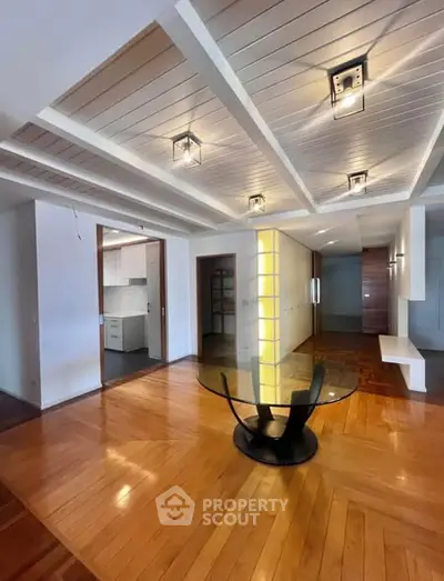 Spacious modern living room with elegant wooden flooring and stylish ceiling lights.